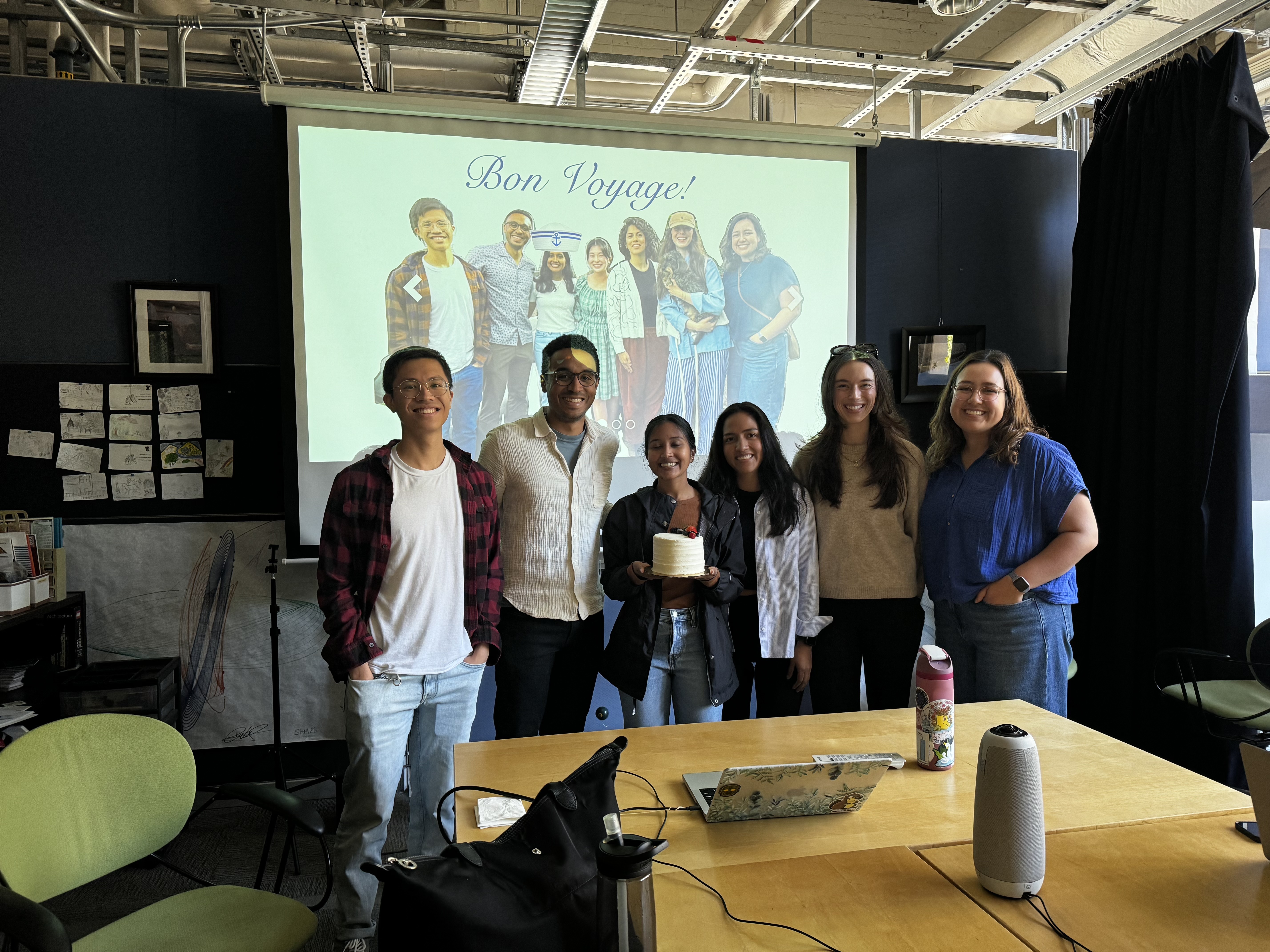 Group photo of the lab in front of a projector