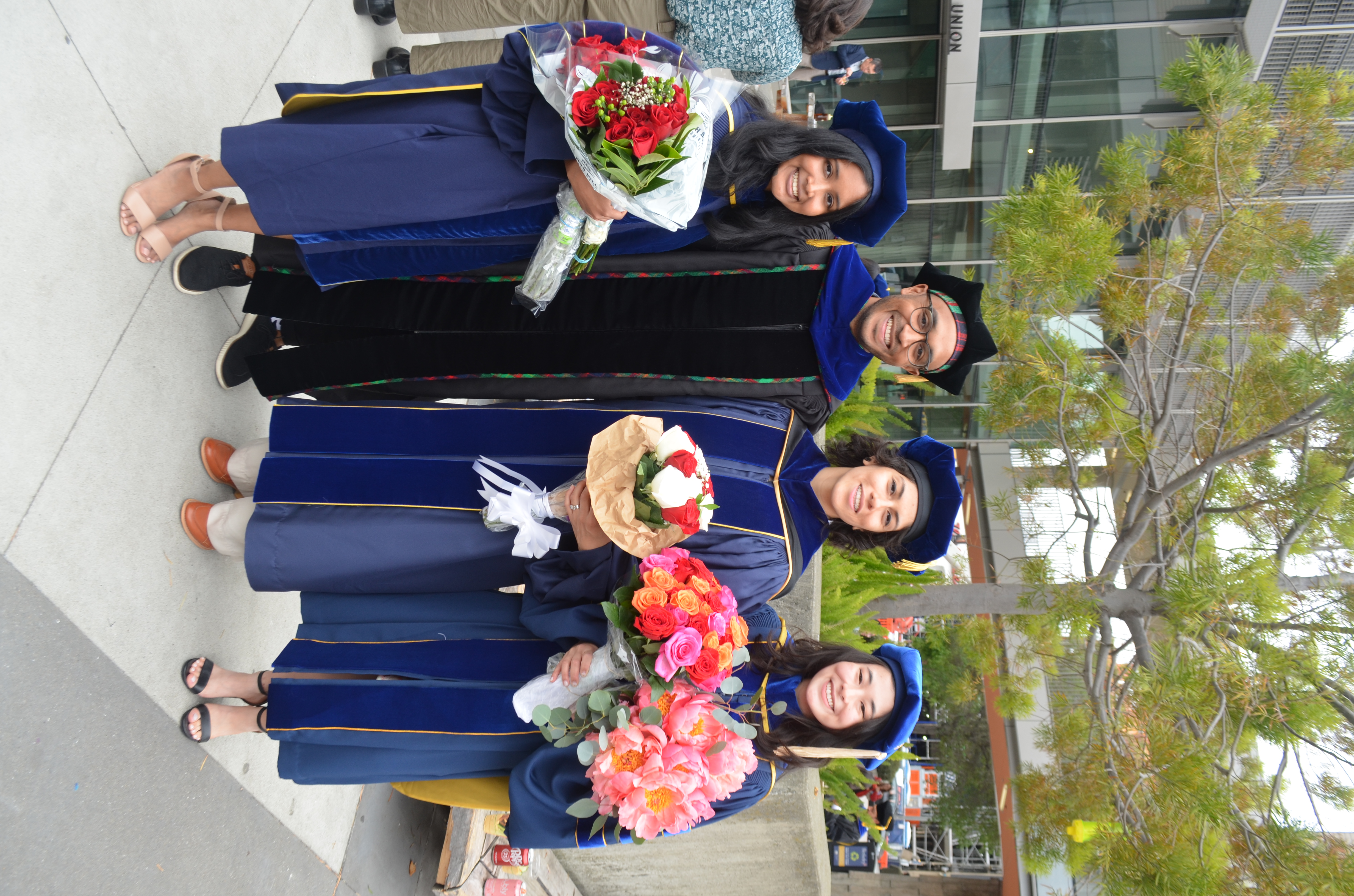 Ananya, Kosa, Yakira, and Elisa posing outside of commencement in regalia
